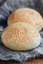 Tasty buns with sesame on wooden, burlap background Royalty Free Stock Photo
