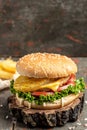 Tasty burger with chicken cutlet and pineapple, fast food and unhealthy eating concept. vertical image Royalty Free Stock Photo