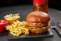 Tasty burger, french fries with sauce and glass of beer on black board Royalty Free Stock Photo