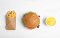 Tasty burger, french fries and sauce on white, top view Royalty Free Stock Photo