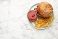 Tasty burger, French fries and sauce on white marble table, top view with space for text. Fast food Royalty Free Stock Photo