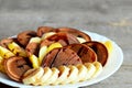 Tasty cacao pancakes. Baked cacao pancakes drizzled with caramel, fresh sliced bananas and apples on a plate Royalty Free Stock Photo