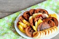 Tasty cacao pancakes with fruit. Baked cacao pancakes with syrup, sliced fresh bananas and apples on a white plate Royalty Free Stock Photo