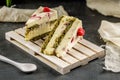 Tasty cake with pistachio and strowberry on the wooden pallet. Sweet homemade wiped cream. Royalty Free Stock Photo