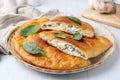 Tasty calzones with basil and cheese on white table, closeup Royalty Free Stock Photo
