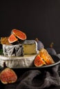 Tasty camembert with fresh figs and honey with honeycombs, decorated on a plate on dark background