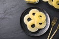 Tasty canned pineapple served on black slate table. Space for text