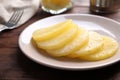 Tasty canned pineapple slices on table, closeup