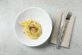 Tasty capellini with mussels and lemon served on light grey table, flat lay. Exquisite presentation of pasta dish