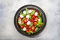 Tasty caprese salad with ripe red tomatoes and mozzarella cheese with fresh green basil leaves. Italian food. Top view Royalty Free Stock Photo