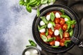 Tasty caprese salad with ripe red tomatoes and mozzarella cheese with fresh green basil leaves. Italian food. Top view Royalty Free Stock Photo