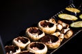 Tasty champignon  mushrooms and veggies being cooked on charcoal grill Royalty Free Stock Photo