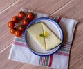 Tasty cheese in a ceramic dish with extra virgin olive oil and cherry tomatoes. Aerial view rustic on a rag and wood Royalty Free Stock Photo
