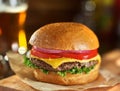 Tasty cheeseburger with beer in background Royalty Free Stock Photo