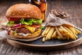 Tasty cheeseburger, glass of cola and french fries on wooden tray close-up Royalty Free Stock Photo