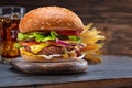 Tasty cheeseburger, glass of cola and french fries on wooden tray close-up Royalty Free Stock Photo