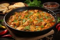 Tasty chicken curry in a pan with wooden spices