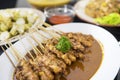 Tasty chicken satay served with other foods