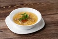 Tasty chicken soup bouillon with noodles, chicken meat, dill and parsley in a white bowl. Isolated on wooden background