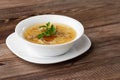 Tasty chicken soup bouillon with noodles, chicken meat, dill and parsley in a white bowl. Isolated on wooden background