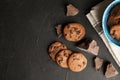 Tasty chocolate chip cookies on dark background, flat lay.