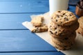 Tasty chocolate chip cookies and glass of milk on blue wooden table, closeup. Space for text Royalty Free Stock Photo