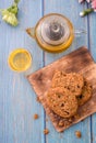 Tasty chocolate chip cookies stacked on a board served with tea and teapot on blue wooden table.Organic homemade snacks for Royalty Free Stock Photo