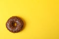 Tasty chocolate donut on yellow background, space for text Royalty Free Stock Photo