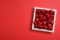 Tasty chocolate heart shaped candies in white box on red background, top view. Space for text Royalty Free Stock Photo