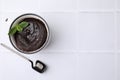 Tasty chocolate mug pie and spoon on white table, top view with space for text. Microwave cake recipe