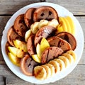 Tasty chocolate pancakes with fresh fruit. Baked chocolate pancakes with syrup, sliced bananas and apples on a white plate Royalty Free Stock Photo
