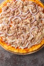 Tasty close up of Italian onion and tuna pizza on the wooden board on the table. Vertical top view Royalty Free Stock Photo