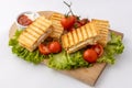 Tasty club sandwiches with ham and cheese on wooden table. Grilled and pressed toast with smoked ham, cheese, tomato and lettuce