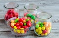 Tasty colorful candies in glass bowl and jars