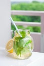 Tasty colorful drink with cold green tea, mint and lemon in a glass jar on a white kitchen background Royalty Free Stock Photo