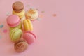 Tasty colorful macarons on trendy pastel pink paper with confett