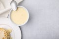Tasty condensed milk, spoon and waffles on light grey table, flat lay. Space for text Royalty Free Stock Photo