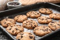 Tasty cookies with chocolate chips on baking tray