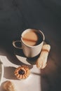 Tasty cookies with jam on top in white plates and hot coffee with window light.