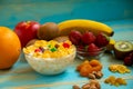 Tasty cornflakes with milk and fruits in glass bowl