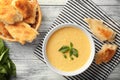 Tasty cornmeal mush with breads and basil leaves on table