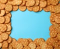 Tasty cracker biscuits on blue background, space for text