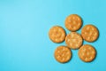 Tasty cracker biscuits on blue background, top view