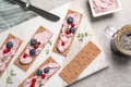 Tasty cracker sandwiches with cream cheese, blueberries, red currants, thyme and cup of coffee on grey table, flat lay Royalty Free Stock Photo