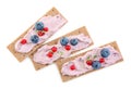 Tasty cracker sandwiches with cream cheese, blueberries, red currants and thyme on white background, top view