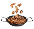 Tasty cracklings falling into frying pan on white background. Cooked pork lard