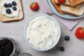 Tasty cream cheese, toasted bread and fresh berries on white wooden table, flat lay Royalty Free Stock Photo