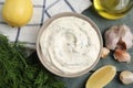 Tasty creamy dill sauce and ingredients on blue wooden table, flat lay