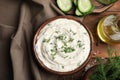 Tasty creamy dill sauce and ingredients on wooden table, flat lay