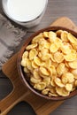 Tasty crispy corn flakes and glass of milk on wooden table, flat lay Royalty Free Stock Photo